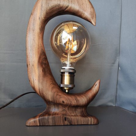 Detalle de las vetas naturales y el casquillo metálico vintage en lámpara de madera estilo rústico moderno.